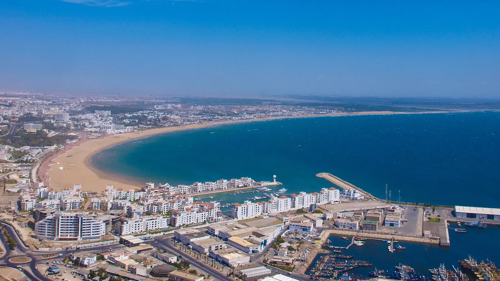 Aerial view of Agadir bay: the curving beach, the Marina and the city between the hills and the Atlantic