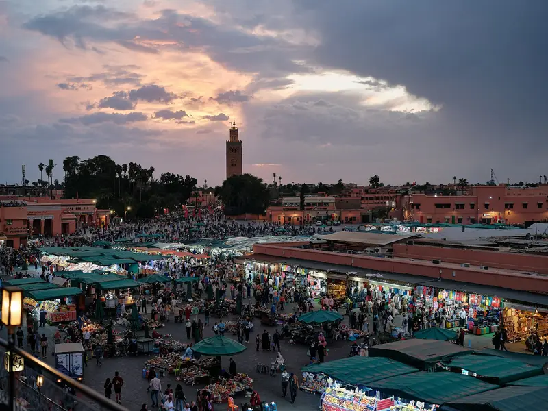 Jemaa el-Fnaa square in Marrakech at dusk with the Koutoubia minaret on the skyline